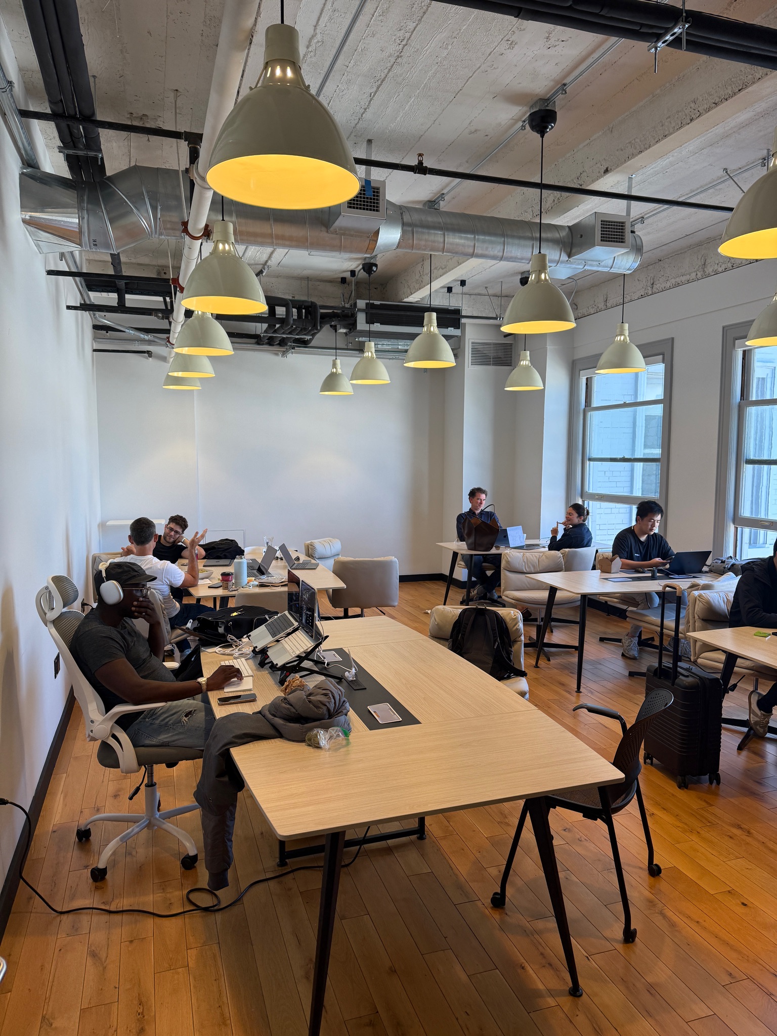 Open coworking space with wooden tables and pendant lights