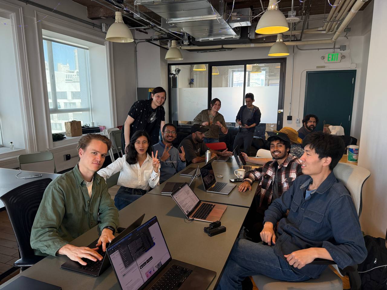 Hackathon session with people collaborating on laptops in the conference room